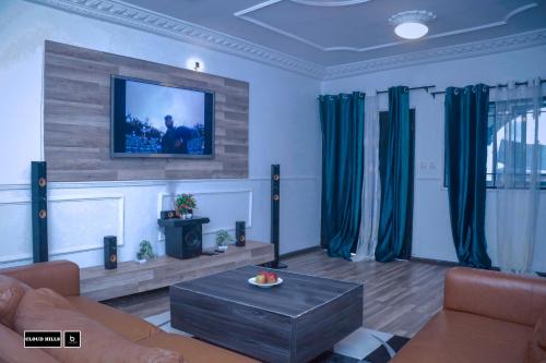 BueaCloud Hill的客厅配有沙发和墙上的电视
