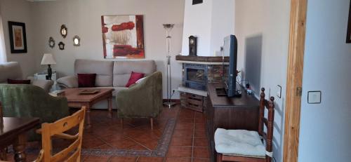 VilvestreCasa Obdulia的带沙发、桌子和电视的客厅