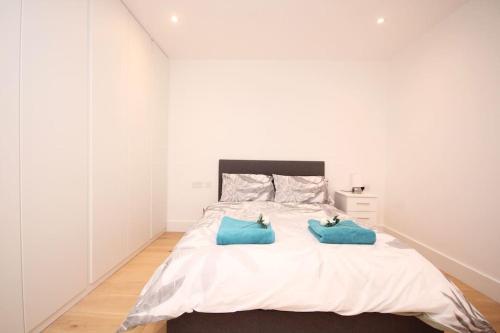 伦敦Lovely flat in Baker street的一间卧室配有一张带两个蓝色枕头的床