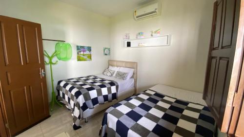 阿拉卡茹Chácara Paraíso do Rio em Aracaju的一间卧室设有两张床和一扇门