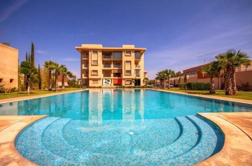 马拉喀什appartement moderne au style beldi résidence au centre de Marrakech avec piscine的大楼前的大型游泳池