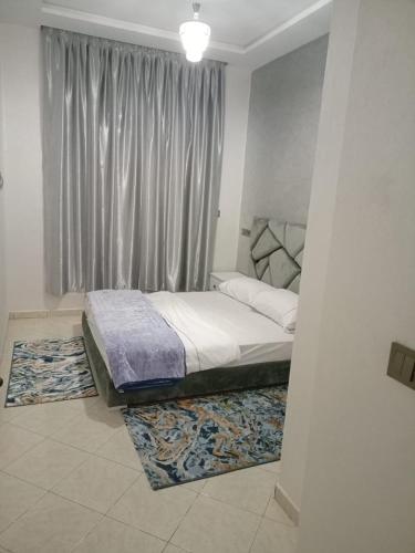 阿加迪尔أكادير حي السلام的一间卧室配有一张带窗户和地毯的床
