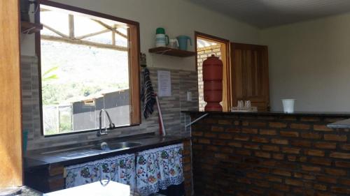 伊比科阿拉Chalet Vida de Roça的厨房设有水槽和窗户。