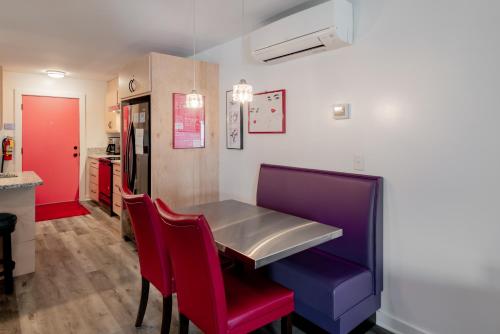 富丽海滩Folly Vacation Perfect Purple Palace Apt A的一间配备有桌子和红色及紫色椅子的用餐室