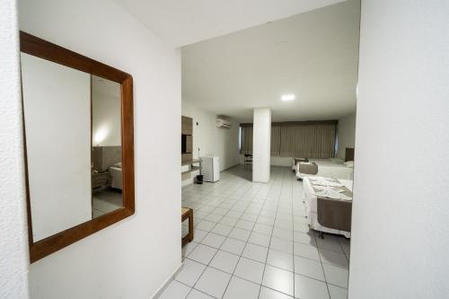 福塔莱萨普拉亚马尔酒店的一间带镜子的客厅和一间带床的房间