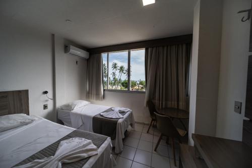 福塔莱萨普拉亚马尔酒店的酒店客房设有两张床和窗户。