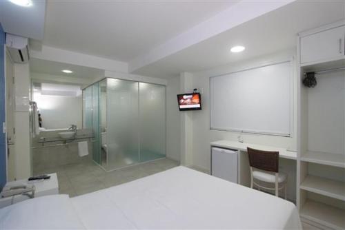 弗洛里亚诺波利斯唐泽佩酒店的卧室配有白色的床、水槽和淋浴