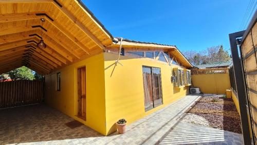 洛斯安第斯Casa Los Andes的黄色的房子,有门和栅栏