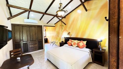 比亚维森西奥Tequendama Hotel Campestre Villavicencio的卧室配有1张床、1张桌子和1把椅子