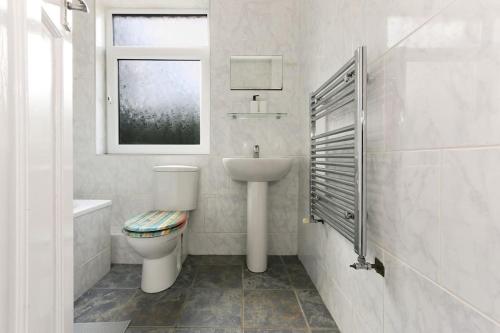 Nether EdgeSemi-Detached House Featuring a Mezzanine Level的白色的浴室设有卫生间和水槽。