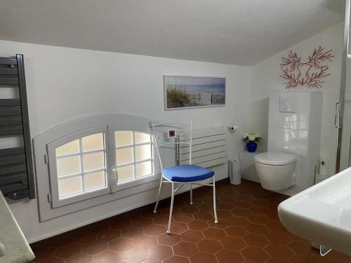 卡尔卡托吉奥Villa les Palmiers的一间带卫生间和蓝色凳子的浴室