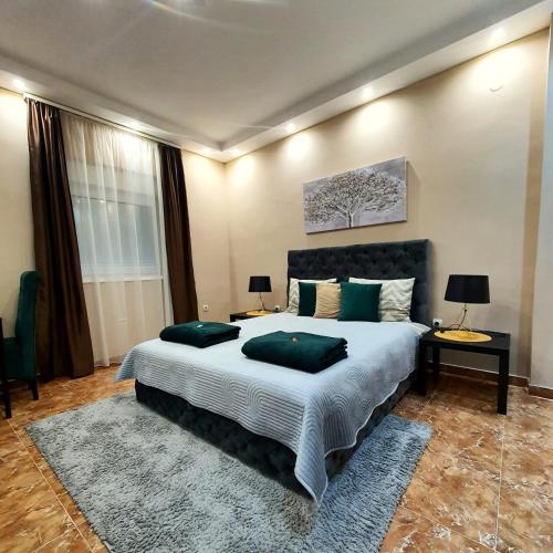 Senjak (historical)Emerald Apartment Belgrade的一间卧室配有一张大床和两个绿色枕头