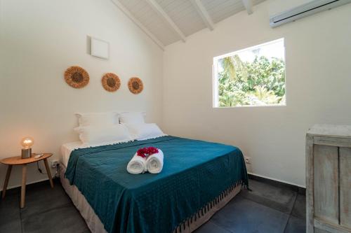 圣安尼La Petite Caravelle Guadeloupe的一间卧室配有一张床,上面有两条毛巾