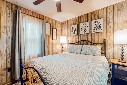 克莱顿White Pine Perch的一间卧室设有一张床和木墙
