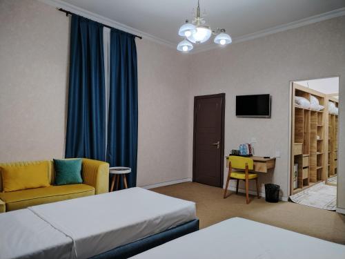 巴库Pera Hotel Baku的酒店客房配有两张床、一把椅子和一张书桌