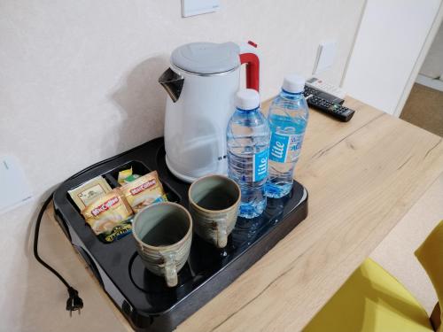 巴库Pera Hotel Baku的盘子,盘子上放着两个水瓶和杯子
