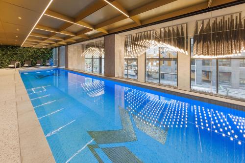 墨尔本Meriton Suites King Street Melbourne的大楼内一个蓝色的大型游泳池
