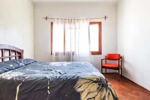瓜伊马延La Juana Mza的一间卧室配有一张床和一张红色椅子