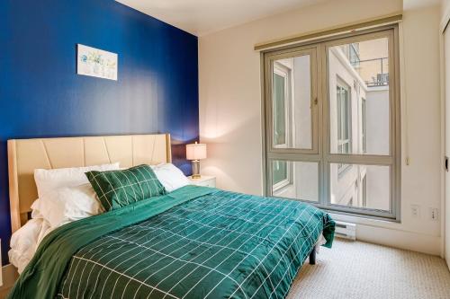旧金山San Francisco Condo Less Than 1 Mi to Union Square!的一间卧室配有一张蓝色墙壁的床和一扇窗户