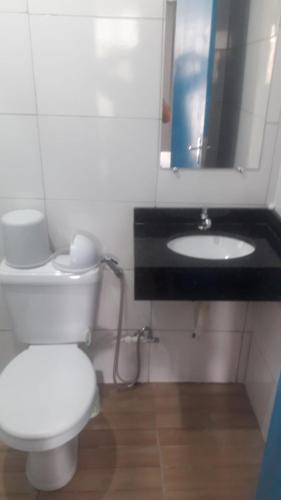 巴拉那瓜Pousada Tia Tina的浴室配有白色卫生间和盥洗盆。
