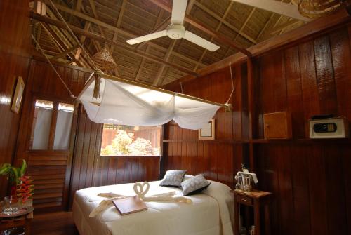 马尔多纳多港Sandoval Lake Lodge的一间卧室设有一张带窗户和天花板的床。