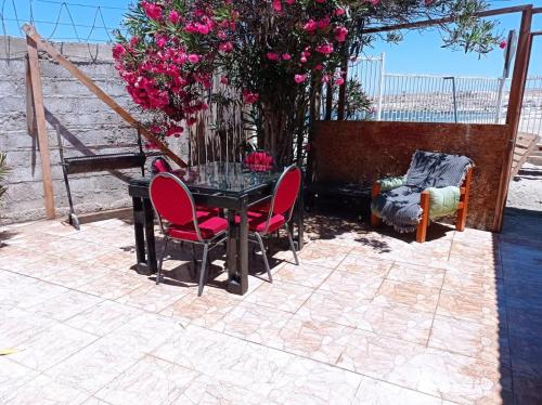 卡尔德拉Suite Loreto的庭院里摆放着一张桌子和椅子,上面摆放着粉红色的鲜花