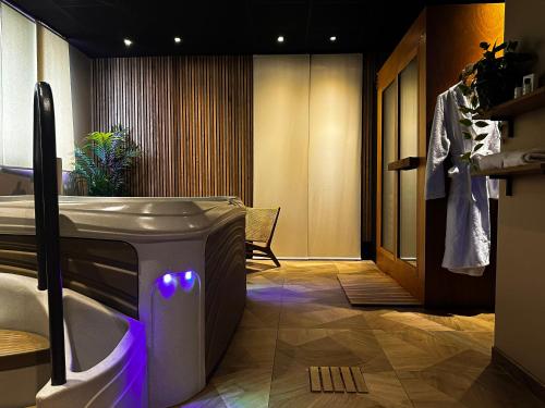 香槟沙隆HOTEL & SPA Le Renard Centre的带浴缸和紫色灯水槽的浴室