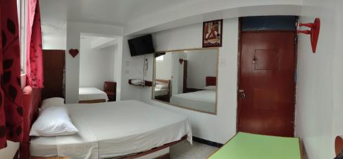 利马Hostal Reyna的一间小卧室,配有两张床和镜子
