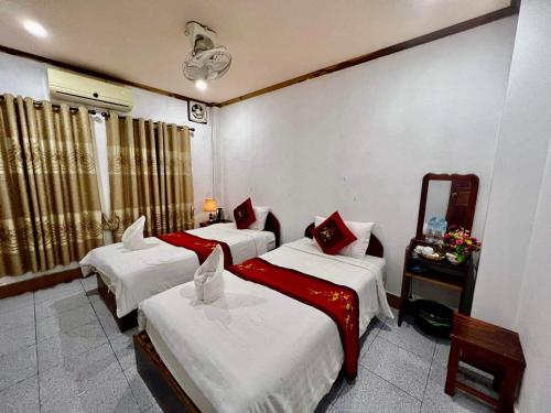 琅勃拉邦Luang Prabang Rosie Place的酒店客房,设有三张床和镜子