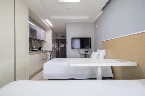 仁川市GL City Hotel Incheon Airport的酒店客房带一张床和一个厨房