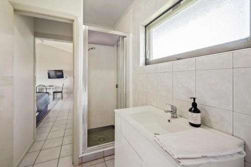 罗托鲁瓦Jack & Di's Lakefront Motel的白色的浴室设有水槽和窗户。