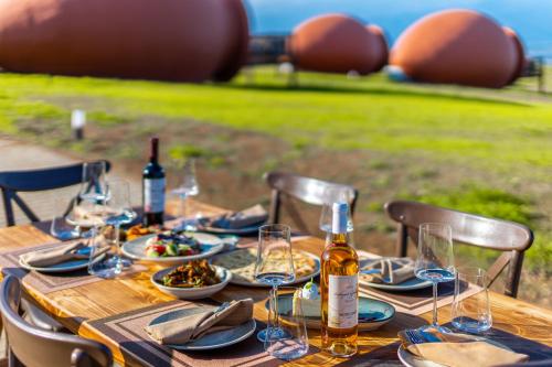 泰拉维Hotel Qvevrebi的木桌,带食物和酒杯盘
