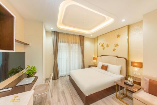 胡志明市Simmi Apartment Phu My Hung的酒店客房配有一张床、一张书桌和一台电脑