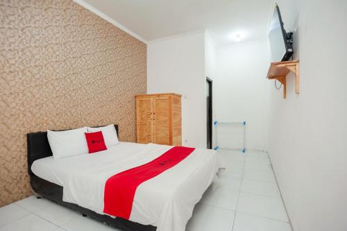 贝克西RedDoorz Syariah near Jatisampurna Hospital的一间卧室配有一张带红白毯子的床