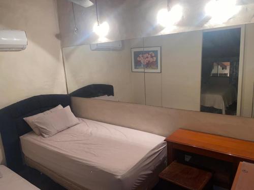 圣贝纳迪诺Country village San Bernardino的一间小卧室,配有一张床和镜子