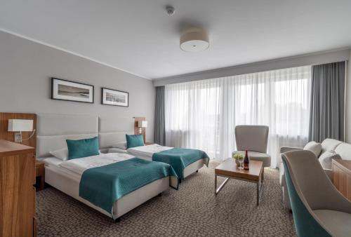 米兹多洛杰沃林酒店的酒店客房,配有床和沙发