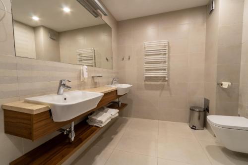 米兹多洛杰沃林酒店的一间带两个盥洗盆和卫生间的浴室