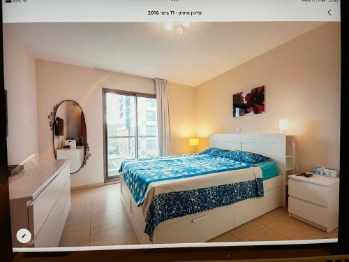 荷兹利亚Luxury apartment on the beach的一间卧室配有床、水槽和窗户