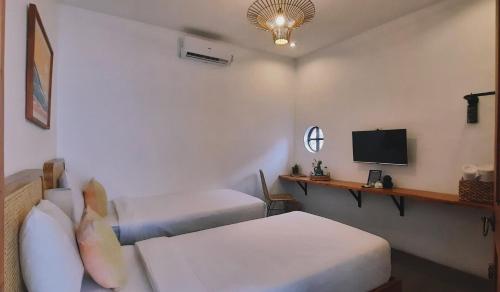 外南梦Betah Homestay Banyuwangi的酒店客房设有两张床和电视。