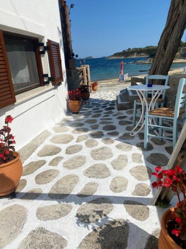 阿莫利亚尼岛IRENE traditional apartments的一个带桌椅的庭院和海滩