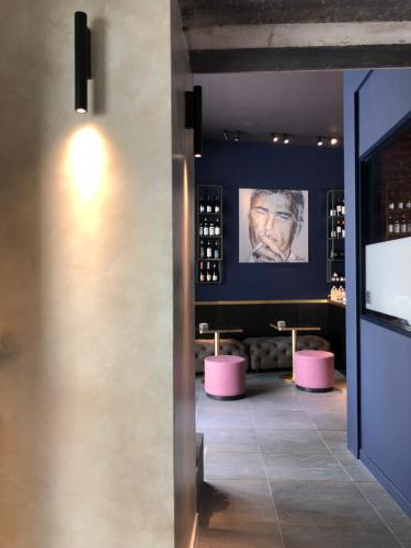 多莫多索拉Palazzo 7的酒吧,有粉红色的凳子和一张男人的照片