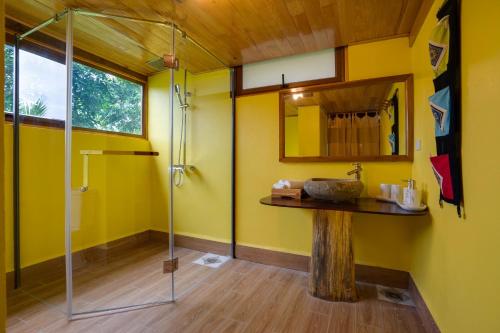 枚州县Mai Chau Onsen Retreat的一间带玻璃淋浴间的浴室,铺有木地板