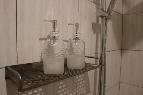 吉利特拉旺安BALE DATU BUNGALLOW的浴室内架上的两瓶牛奶