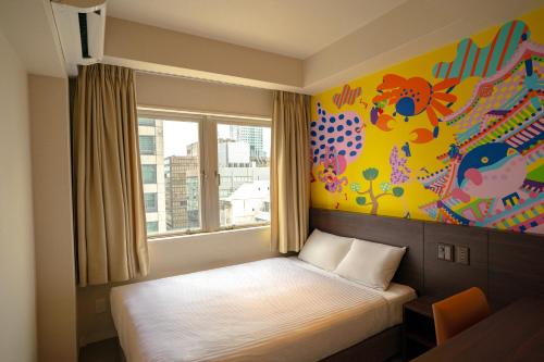 大阪Lub d Osaka Honmachi的墙上画的一张床上