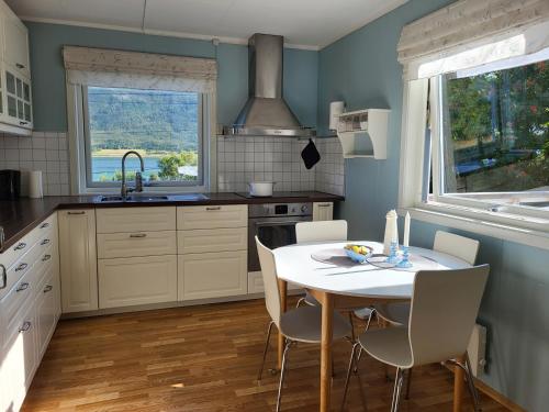 Nord-LenangenIdyllisk hus med sauna og jacuzzi, Lyngen的厨房配有桌椅和水槽。