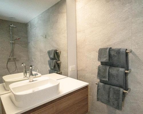 克伦威尔Pisa House Lakefront Boutique B&B的浴室设有白色水槽和镜子
