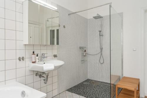 不莱梅Jugendstil-Traumwohnung direkt am Weserstadion的白色的浴室设有水槽和淋浴。