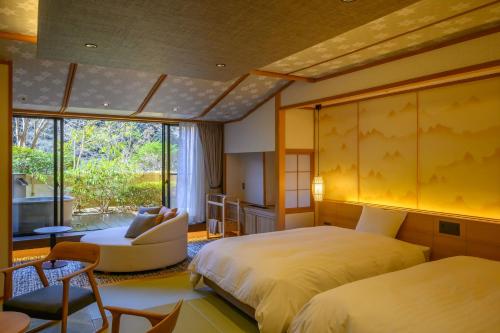 涩川市福一酒店的一间卧室设有两张床、一把椅子和一个窗户。