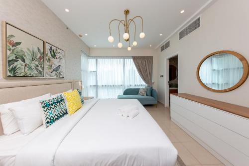 迪拜Charming Brand New 2BR close to the Beach的卧室配有一张白色大床和镜子