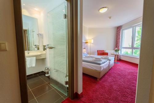 文迪施里茨Einklang - Dein Hotel am Südhorn的一间卧室配有一张床,浴室设有淋浴。